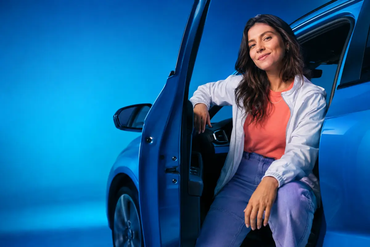 Mulher sentada em carro azul - Azul por Assinatura, seguro auto mensal